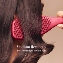 Model styling hair with the Tangle Teezer Complete Carebrush in Glossed Raspberry
