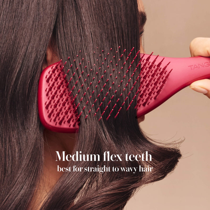 Model styling hair with the Tangle Teezer Complete Carebrush in Glossed Raspberry